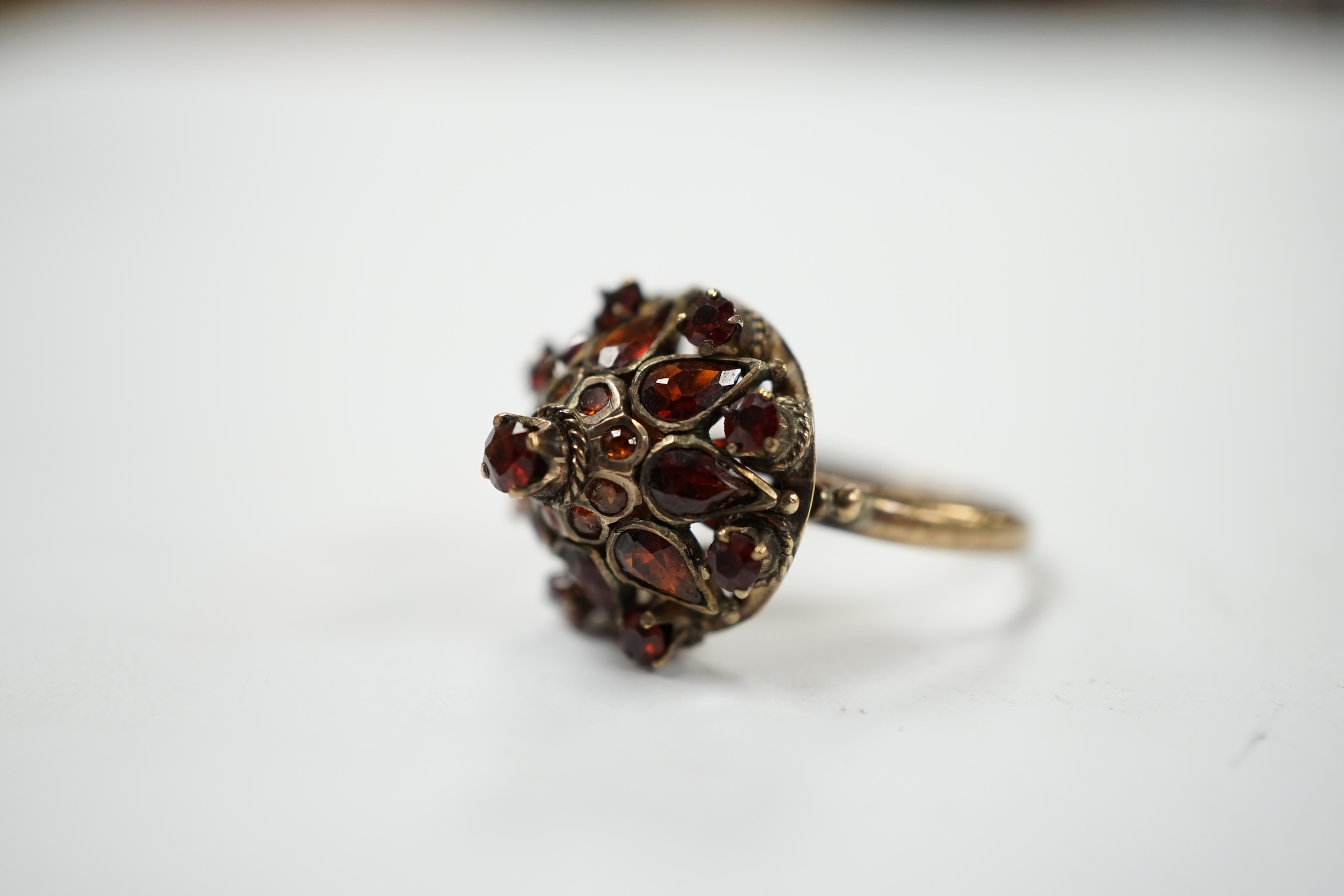 A 14k and garnet cluster set domed dress ring, size M/N, gross weight 3.4 grams. Condition - fair